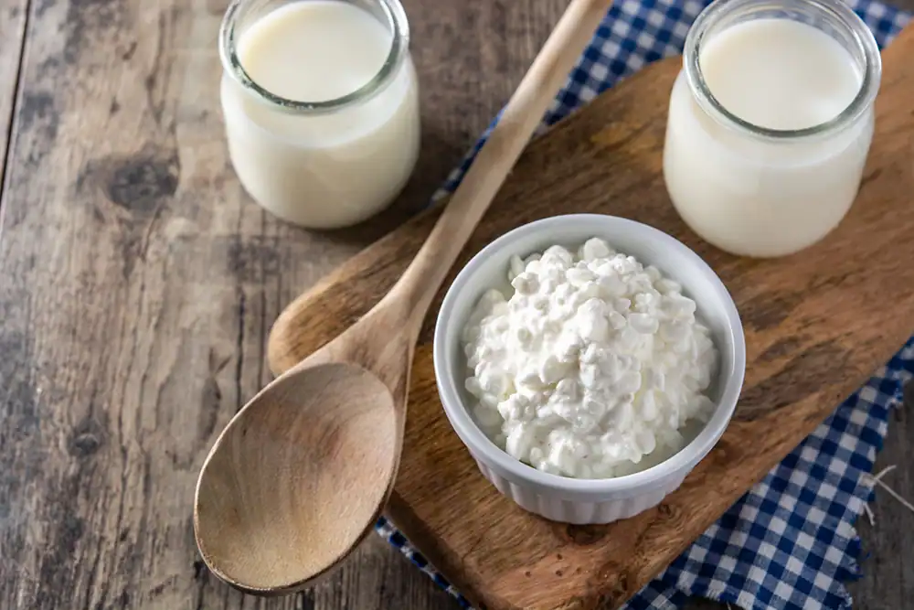 Fresh cottage cheese and milk served on rustic wooden table for a healthy breakfast or snack.
