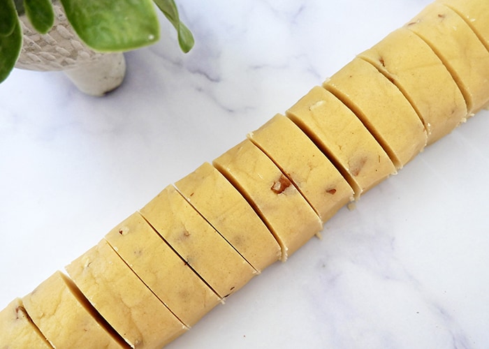 A sliced roll of Jogue Bourbon Pecan Shortbread cookie dough.