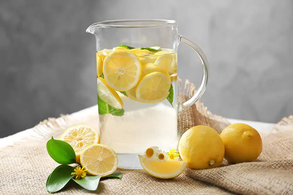 Refreshing lemon-infused water with slices of lemon and fresh mint in a glass pitcher, ideal for healthy hydration and detox. Perfect for summer drinks, wellness, and flavorful hydration.