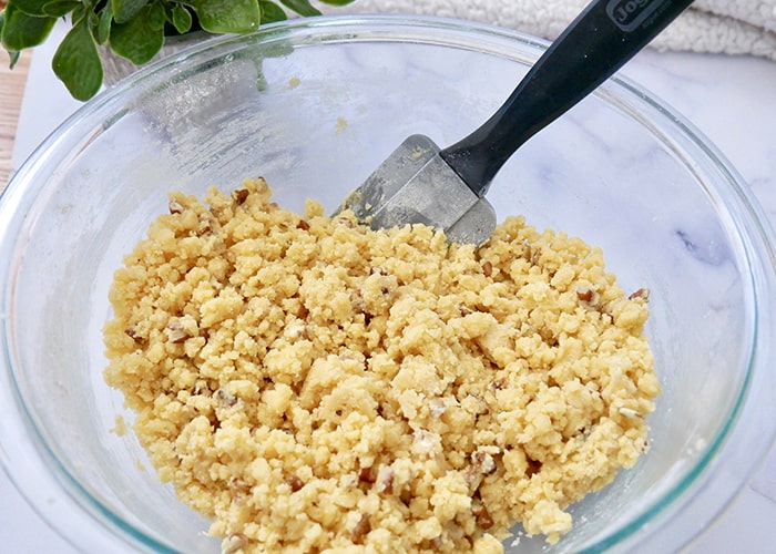 Bourbon Pecan Shortbread cookie batter being mixed in a glass bowl.
