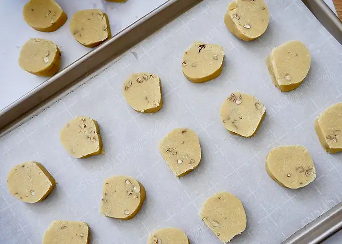 Unbaked Bourbon Pecan Shortbread Cookies on a tray.